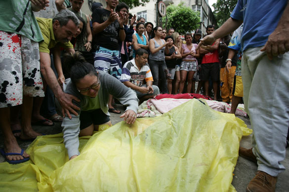 Rio de Janeiro: Maria da Costa Gomes, bottom left, mourns over the body of her son Marcelo