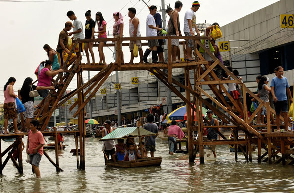 Philippines flooding: 17 October 2009: Pedestrians walk over a makeshift overpass