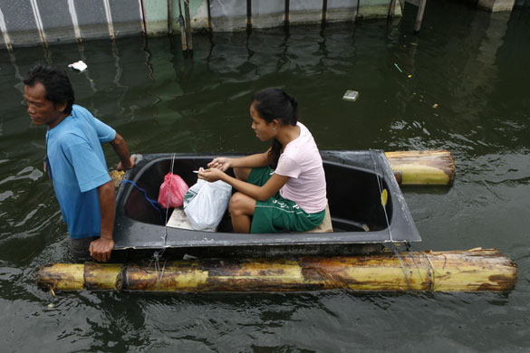 Philippines flooding: 15 October 2009: A woman sitting on an improvised raft
