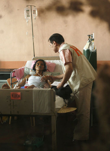 Philippines flooding: 19 Ocotber 2009: Health secretary Francisco Duque III with a patient
