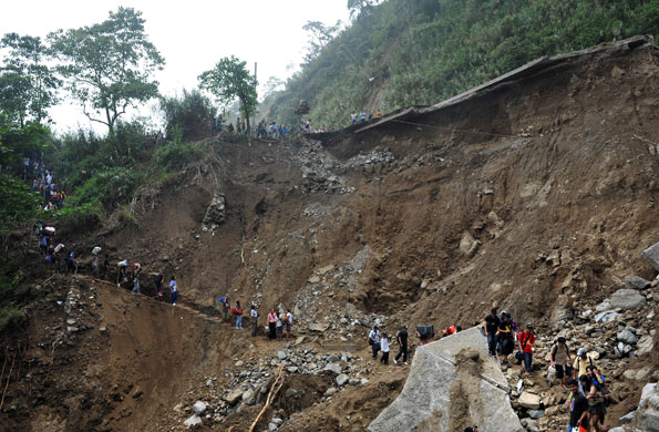 Philippines flooding: 12 October 2009: Stranded commuters walking along a footpath