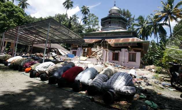 Sumatra earthquake: Residents pray in front of a damaged mosque in the coastal town of Pariaman