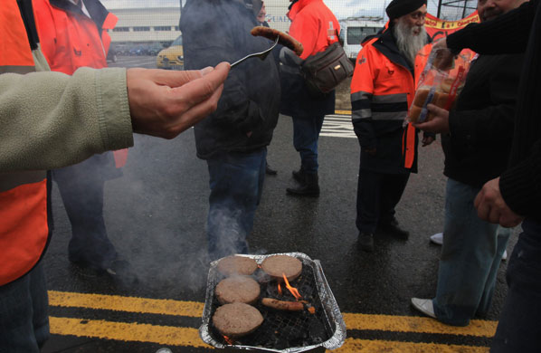 Postal strike: Bristol:  Striking postal workers cook food on a picket line 