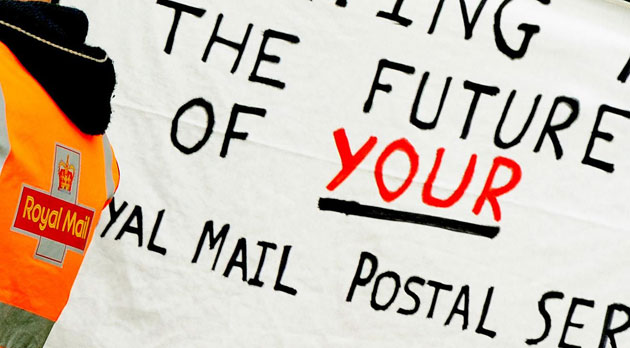 Postal strike: Coventry: A Royal Mail postal worker and picket banner outside the centre 