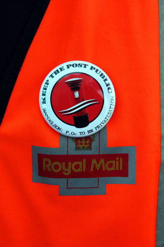 Postal strike: London: A postal worker wears a badge outside East London Mail Centre