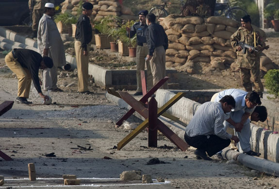 more bombings in pakistan: Security forces survey the site of a suicide bomb in Kamra, Pakistan