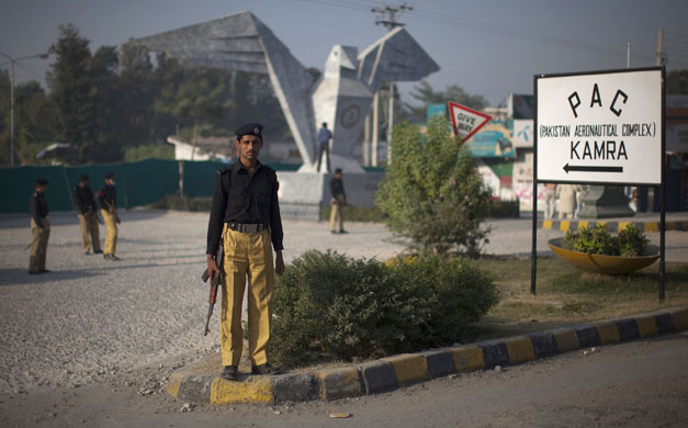 more bombings in pakistan: Policemen stand guard near the site of a suicide bomb attack in Kamra