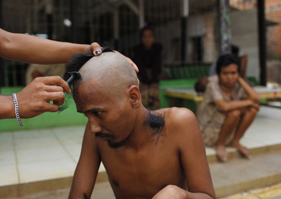 24 hours: A nurse shaves the head of a mental patient in Indonesia