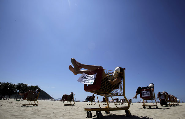 24 hours: Demonstrators sit in supermarket carts at a protest about violence in Rio 