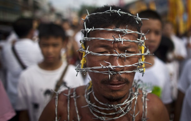 24 hours: A devotee wears a ring of barbed wire at the Vegetarian Festival in Phuket