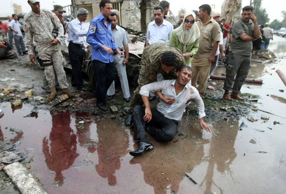 Bomb in Baghdad: An Iraqi man is assisted as he grieves following a suicide bombing