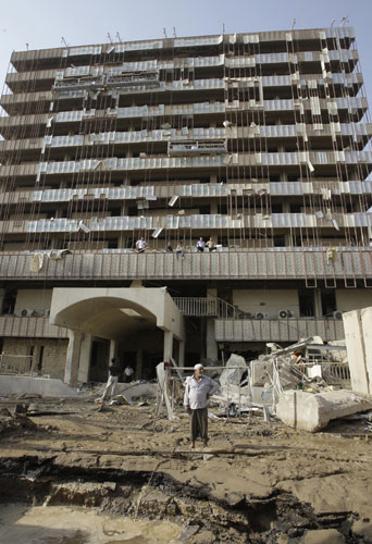 Bombs in Baghdad: An Iraqi man surveys the site of a crater a day after a suicide bombing