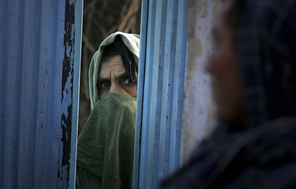 kabul attacks: Local woman looks on during an attack on a  U.N. guest house in Kabul