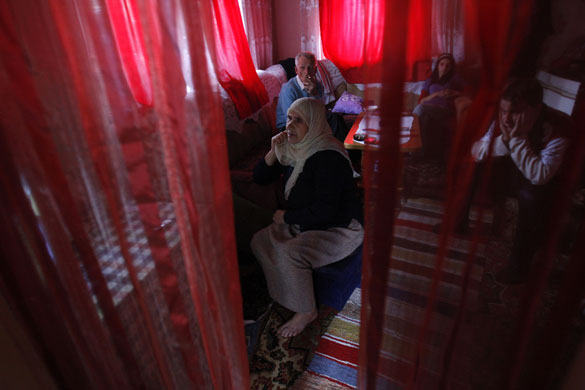 24 hours in pictures: bosnian muslims watch a TV news report of the trial of Radovan Karadzic
