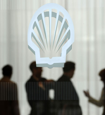 Week in business: Workers behind a logo for oil company Shell at offices in London.