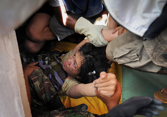 24 Hours in Pictures: Woman rescued from collapsed building after quake in Padang