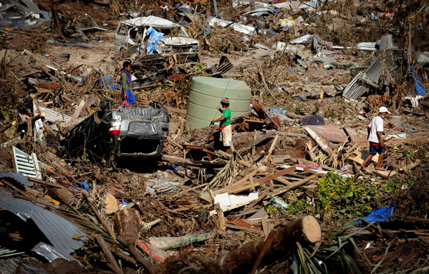 24 Hours in Pictures: Boys looking for items to salvage after Tsunami in Samoa