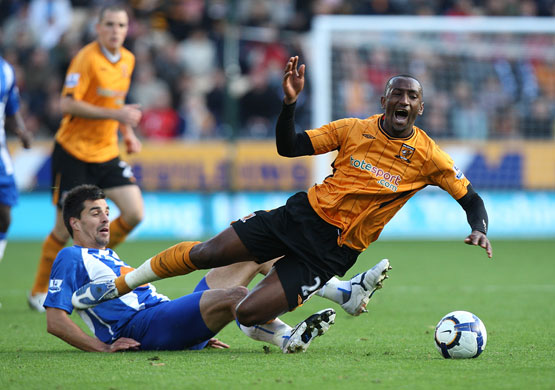 Saturday Premiership: Hull City's Kamil Zayatte is fouled by Wigan's Paul Scharner