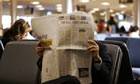 A commuter reads The Wall Street Journal while waiting for his flight