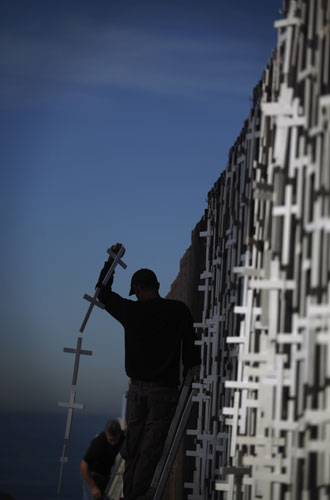 24 hours in pictures: Volunteers from the Pro-migrant Defense Coalition hang crosses in Mexico