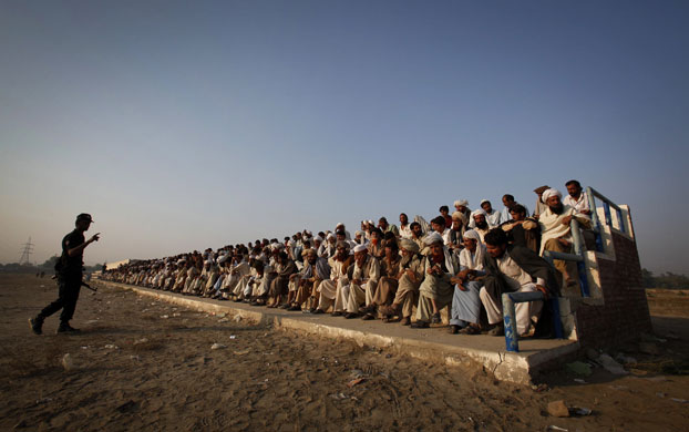 24 hours in pictures: A policeman deliversinstructions to internally displaced men