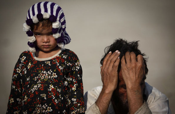 24 hours in pictures: Suraiya and her father wait for handouts at a distribution point