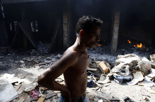 24 hours : Padang, Indonesia: A man  walks through what used to be a market 