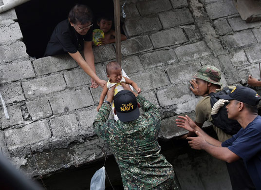 24 hours : Philippine Navy rescuers extract a sick baby after floods