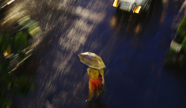 5 October 2009: Mumbai, India: A woman walks in the rain