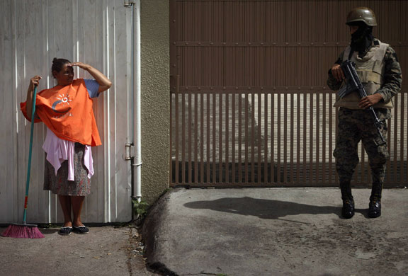 24 hours: A woman looks at a soldier outside the Brazilian embassy in Tegucigalpa
