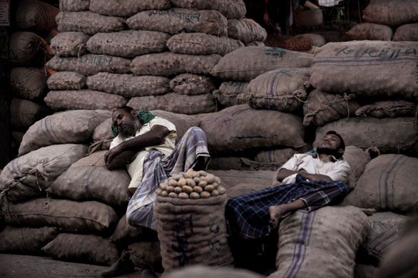 7 October 2009: Dhaka, Bangladesh: Potato vendors sleep at Karwan Bazar
