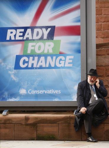 Conservative conference 3: A delegate sits by a sign outside Britain's Conservative Party Conference