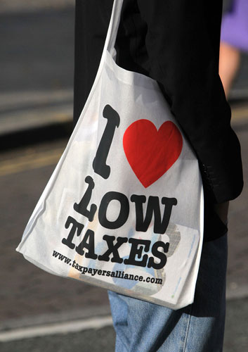 Conservative conference 3: A delegate carries a bag declaring 'I love low taxes'