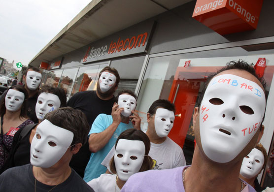 Week in business: France Telecom employees wearing a masks demonstrate