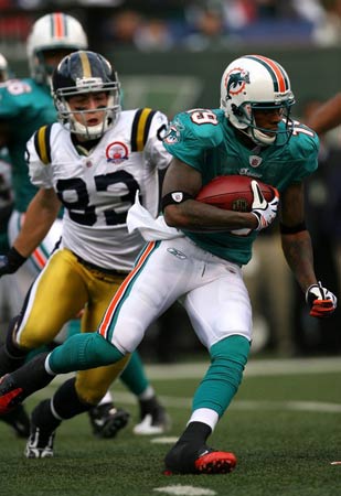 Ted Ginn of the  Miami Dolphins returns a kick-off for a touchdown against the New York Jets