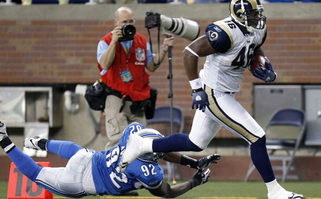 Daniel Fells of the St. Louis Rams runs past Cliff Avril of the Detroit Lions for a touchdown