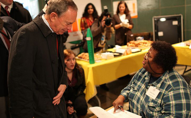 New York City Mayor Michael Bloomberg speaks with a poll worker 