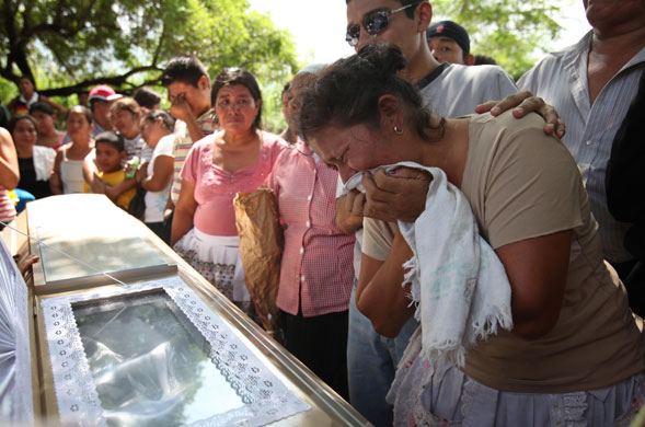 El Salvador hurricane: A woman cries over a coffin who died during flooding in Verapaz