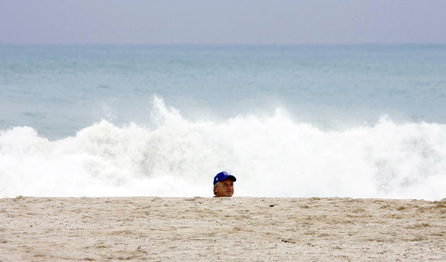 24 hours: A man walks on the beach in Cancun as Hurricane Ida passes miles offshore