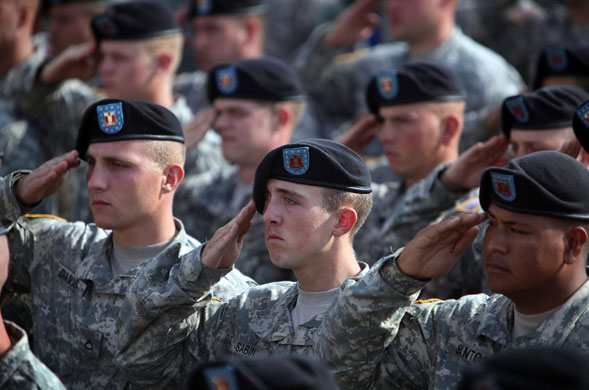 Obama visits Fort Hood: Soldiers salute during the playing of taps at the memorial service