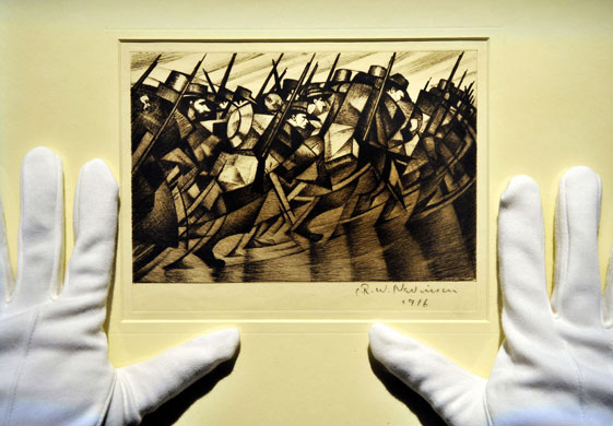 Lord Attenborough auction: A technician adjusts CRW Nevinson's Returning to the Trenches