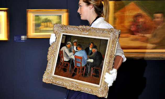 Lord Attenborough auction: A Sotheby's technician holds Christopher Wood's The Card Players