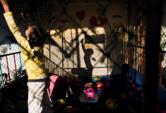 24 hours: Gaza City, Gaza: A Palestinian girl plays inside a ball cage