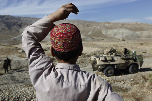 24 hours: An Afghan boy watches NATO French Foreign Legion soldiers 
