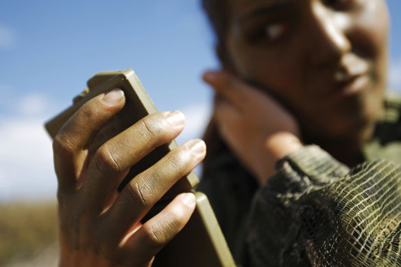 24 hours: Israel:  female soldier from an infantry unit applies camouflage face paint
