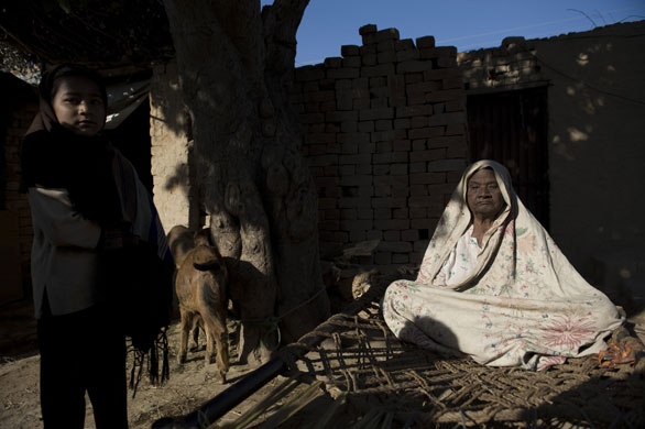 24 hours: Rawalpindi, Pakistan: A girl stands next to her blind grandmother