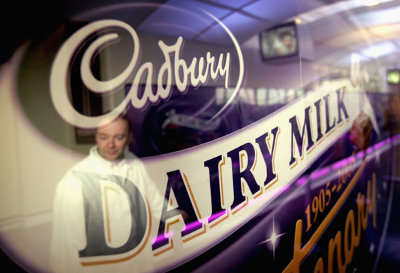 Week in Business: A worker is reflected in the Cadbury's chocolate logo
