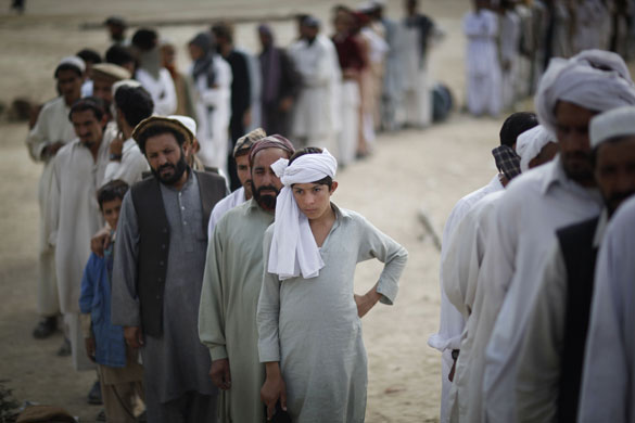24 Hours in Pix: Displaced Pakistani tribal people wait for relief supplies 