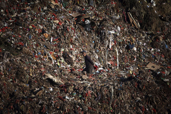 24 Hours in Pix: A man walks to the upper part of a dumping site on the outskirts of Kunming