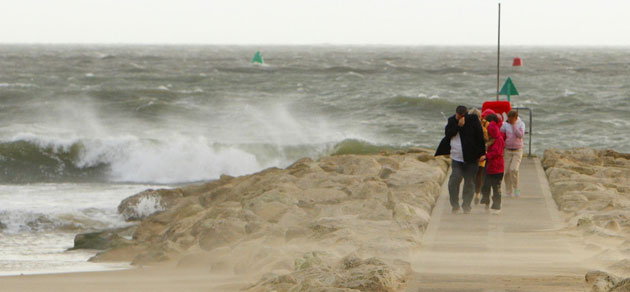 UK gales: A family shields itself from the wind and sand at Sandbanks
